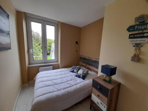 um quarto com uma cama grande e uma janela em Appartement Perros-Guirec, 3 pièces, 4 personnes - FR-1-368-167 em Perros-Guirec