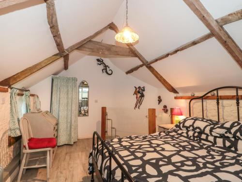a bedroom with a bed and a ceiling with beams at The Coach House in Somerton