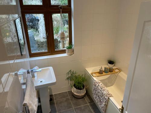 ein Badezimmer mit einem Waschbecken, einer Badewanne und einem Waschbecken in der Unterkunft 3 Bed Ground Floor Apartment - Hot Tub Optional in Hythe