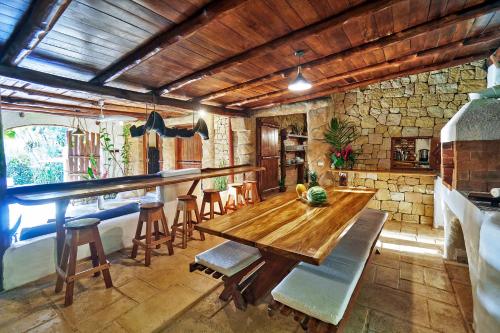 a dining room with a wooden table and chairs at Havana Lodge in Mal País