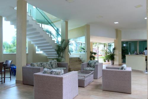 a lobby with couches and chairs and a staircase at Star Hotel in Jericoacoara