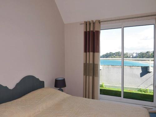 une chambre avec un lit et une grande fenêtre dans l'établissement Maison à 250m de la plage avec terrasse et vue mer à Perros-Guirec - FR-1-368-191, à Perros-Guirec