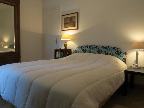 une chambre avec un grand lit blanc et deux lampes dans l'établissement Appartement 350m de la plage du Coz-Pors à Trégastel avec jardin et parking - FR-1-368-192, à Trégastel