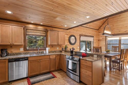 a kitchen with wooden cabinets and a dining room with a table at 1 Kingfisher in Blowing Rock