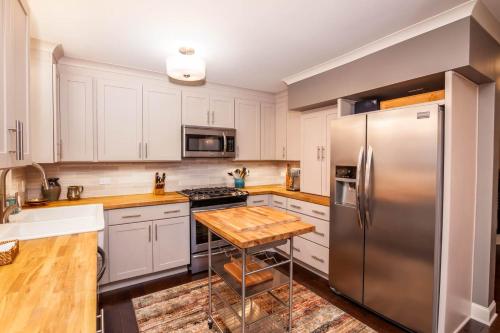 a kitchen with white cabinets and a stainless steel refrigerator at 1eight3 Retreat in Blowing Rock