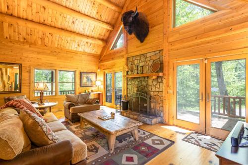 a living room with a fireplace in a log cabin at A Beary Good Time in Boone