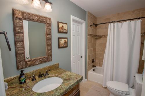 a bathroom with a sink and a toilet and a mirror at Ace of Diamonds in Seven Devils