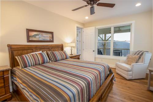 a bedroom with a bed and a chair and a window at Alpine Gorge View in Blowing Rock