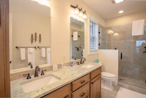a bathroom with two sinks and a toilet and a mirror at Alpine Gorge View in Blowing Rock