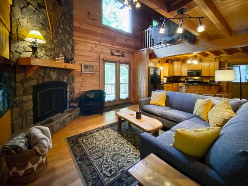 a living room with a blue couch and a stone fireplace at Almost There in Blowing Rock