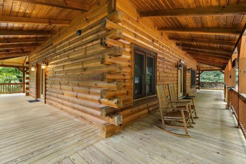 a log cabin with two chairs on the porch at Almost There in Blowing Rock