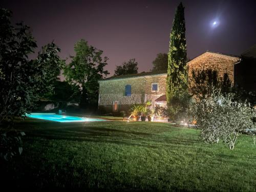 a night view of a house and a church at Mas 1747 - Provence & Charme in Le Pontet