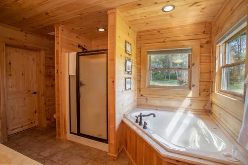 baño con bañera y ventana en Alpine Ridge, en Banner Elk
