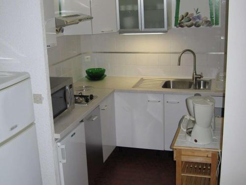 une petite cuisine blanche avec un évier et un mixeur dans l'établissement Grand T2 avec piscine, 4 couchages, superbe plage à 100m, Barcarès - FR-1-81-493, au Barcarès