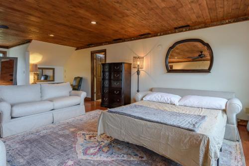 a bedroom with a bed and a couch and a mirror at Appalachian Mountain Lodge in Boone