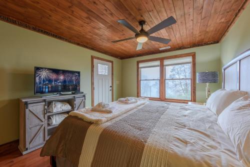 a bedroom with a large bed with a ceiling fan at Appalachian Mountain Lodge in Boone