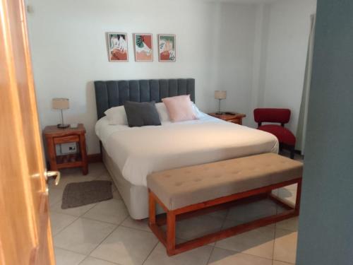 1 dormitorio con 1 cama, 2 mesas y 1 silla en La Pirámide en San Carlos de Bariloche