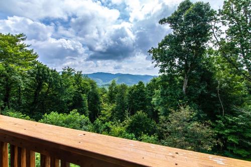 a wooden deck with a view of the forest at Appalachian Ski Mountain Chalet in Blowing Rock