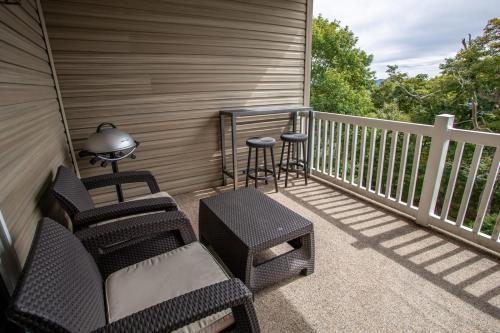 a porch with chairs and a table and a stool at Bear Necessities in Beech Mountain