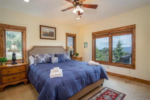 - une chambre avec un lit bleu et un ventilateur de plafond dans l'établissement Bald Eagle Bluff, à Blowing Rock