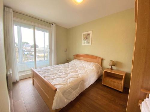 une chambre avec un lit et une grande fenêtre dans l'établissement Appartement T2 Cabine 6 pers avec balcon, à deux pas de la mer et des commerces - La Baule - FR-1-245-136, à La Baule
