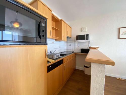 une cuisine avec une grande télévision murale à écran plat dans l'établissement Appartement T2 Cabine 6 pers avec balcon, à deux pas de la mer et des commerces - La Baule - FR-1-245-136, à La Baule