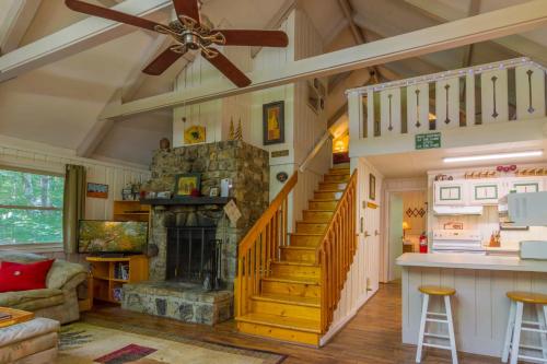 a living room with a staircase and a fireplace at Benzine Farm in Beech Mountain