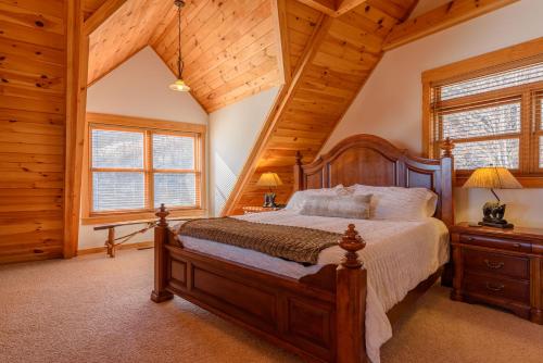 una camera da letto con un letto in una stanza con soffitti in legno di Big Bear Cabin a Banner Elk