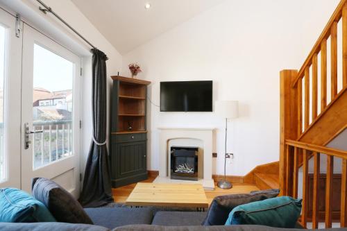 a living room with a couch and a fireplace at Old Stables, hidden period gem, spectacular garden in Bristol