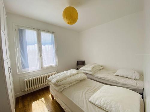 two twin beds in a room with a window at Maison Spacieuse à Carnac - 4 Chambres, Terrasse et Jardin, Proche Plage et Commerces - FR-1-377-45 in Carnac