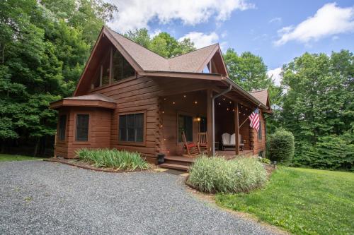 a log cabin with a flag on the porch at Blessed Way Escape in West Jefferson