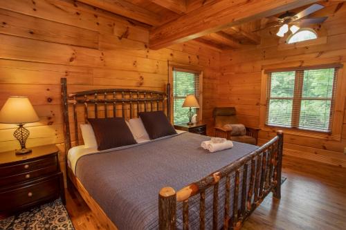 - une chambre avec un lit dans une cabane en rondins dans l'établissement Blessed Way Escape, à West Jefferson