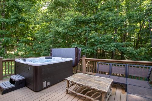 a hot tub and a table on a deck at Blessed Way Escape in West Jefferson