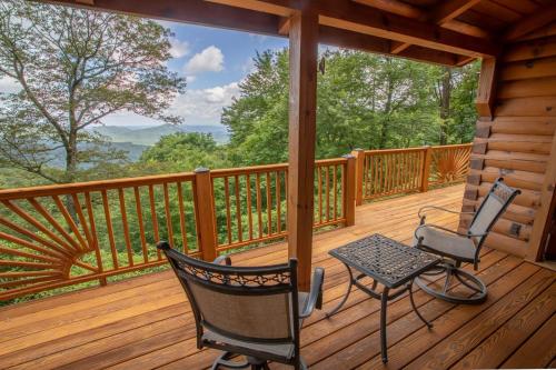 a porch with two chairs and a table on a cabin at Blue Ridge View in Blowing Rock