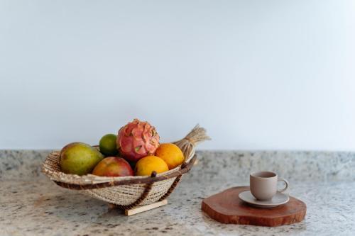 a basket of fruit and a cup of coffee on a counter at Barra Grande, Maraú, Casa 5 in Marau