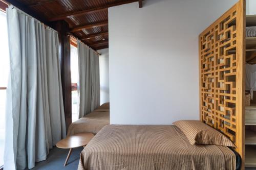 Un dormitorio con 2 camas y una pared con ventanas. en Barra Grande, Maraú, Casa 5, en Maraú