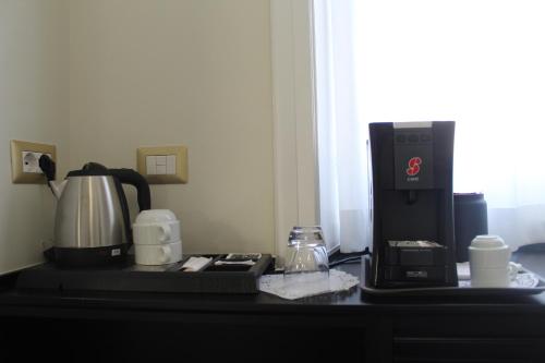 una cafetera y una cafetera sobre una mesa en Sant'Agostino - Luxury Rooms, en Messina