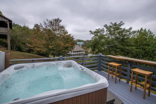 a hot tub on a deck with a table and chairs at Boots Off Bungalow in Boone
