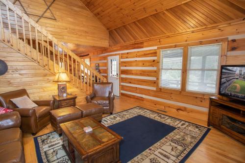 a living room with a couch and a television in a cabin at Boots Off Bungalow in Boone