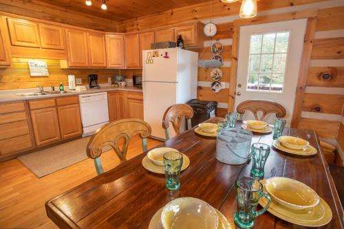 a kitchen with a wooden table and a refrigerator at Boots Off Bungalow in Boone