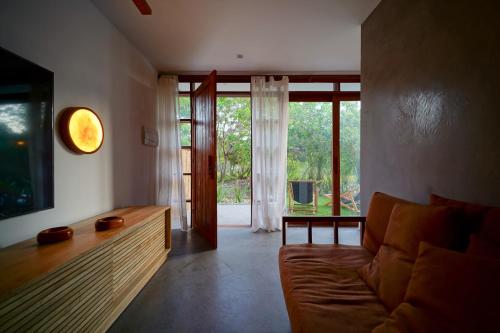 a living room with a couch and a large window at Barra Grande, Maraú, Casa 5 in Marau