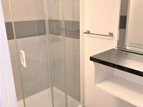 une douche avec une porte vitrée dans une salle de bain dans l'établissement Appartement rénové, bien équipé à 500m de la plage de Trestrignel et du centre-ville de Perros-Guirec - FR-1-368-241, à Perros-Guirec