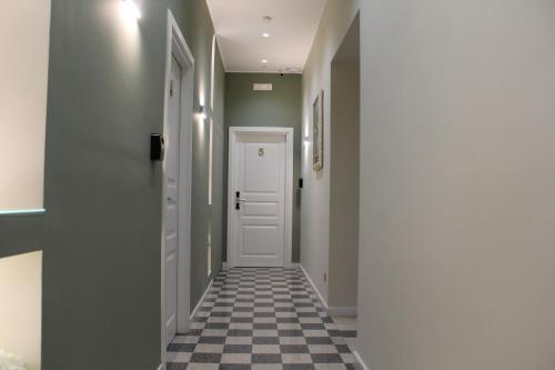 a hallway with a white door and a checkered floor at Sant'Agostino - Luxury Rooms in Messina