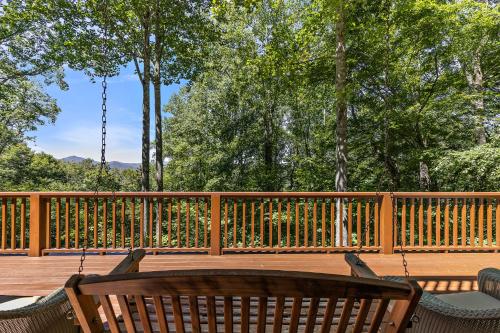 a wooden deck with a swing and a chair at Chimney Island in Blowing Rock
