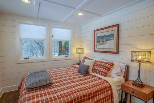 a bedroom with a bed and two windows at Brigadoon in Seven Devils