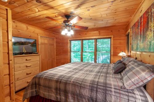 a bedroom with a bed and a ceiling fan at Chestnut Falls in Beech Mountain