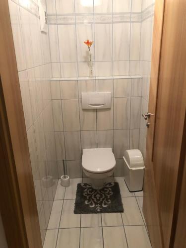 a small bathroom with a toilet and a vase with a flower at Babsi Appartments - leben am Land in Wels