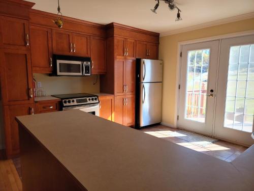 a kitchen with wooden cabinets and a refrigerator at Motel de la mer in Rimouski