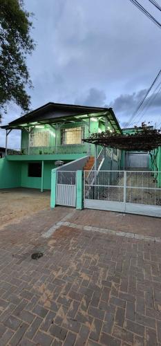 a building with a gate and a brick floor at Casa aconchegante - compartilhada in Cascavel
