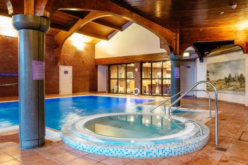 a large swimming pool in a building at Abbey Hotel Golf & Spa in Redditch